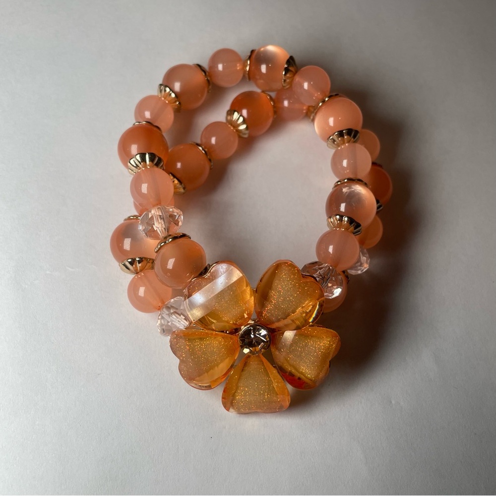 layered beaded bracelet with flower charm
